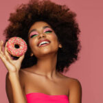 Young beautiful afro woman with donuts