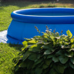 Blue inflatable pool on the lawn of country garden